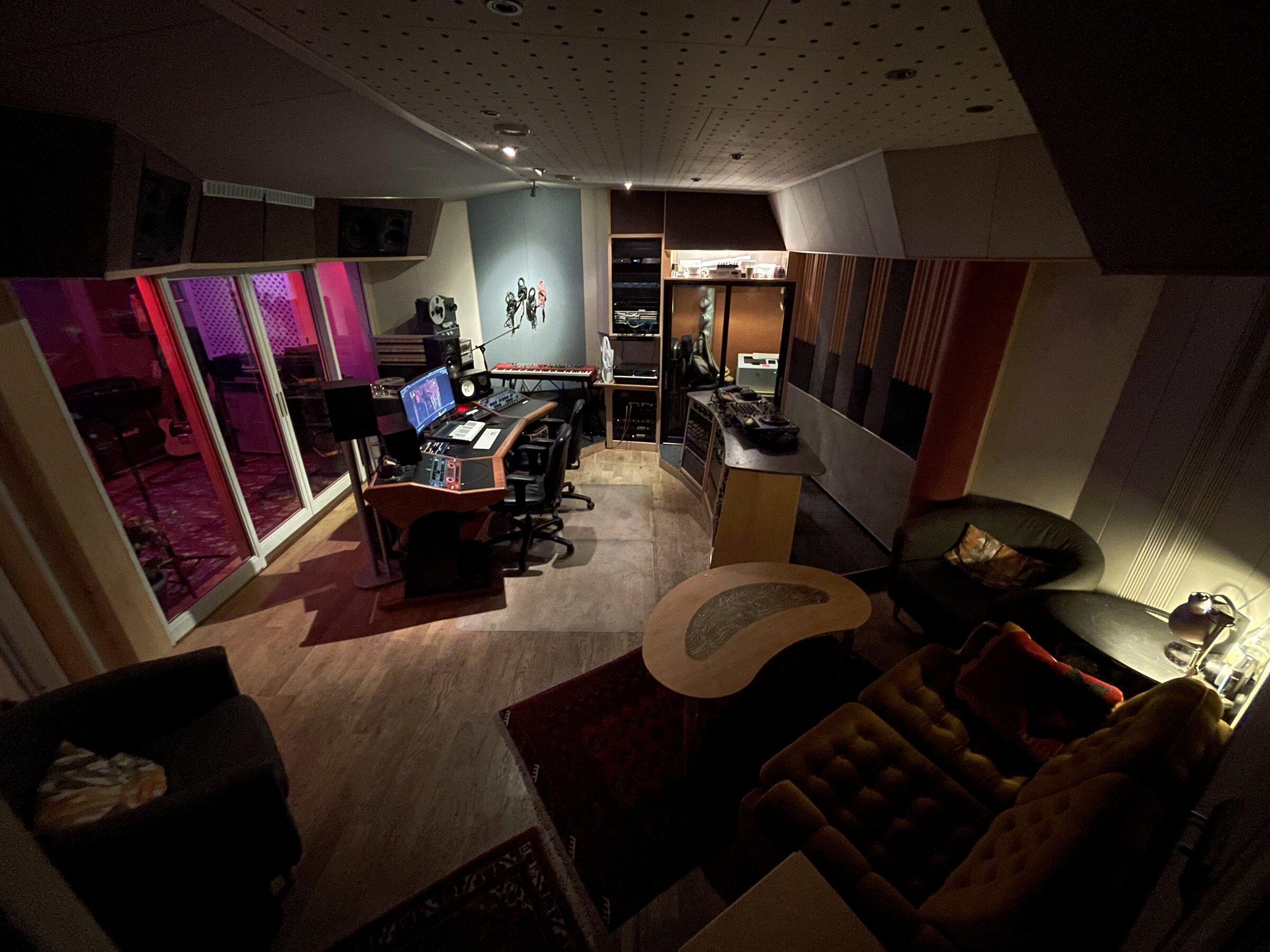 Control room with vintage outboard and view into the live room